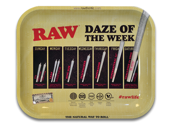 A large rectangular rolling tray with multiple compartments, labeled 'RAW Daze Of The Week'. It includes a section with slots for rolling papers and a metallic rolling tool, placed on a surface with the brand's logo and social media hashtag '#rawlife'.