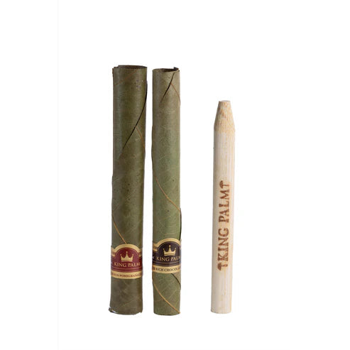 Two King Palm rolling papers and a wooden roller on a white background