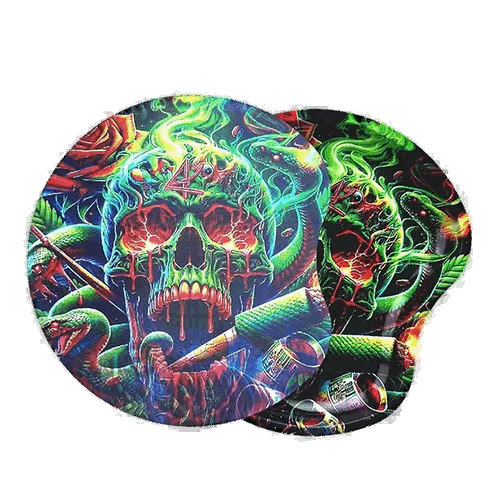This image features a strikingly vibrant and colorful rolling tray, designed with a bold "Inferno Skull" motif. The intricate artwork depicts a vividly detailed skull surrounded by a lush array of greenery and mystical motifs, glowing brightly in various shades of green.