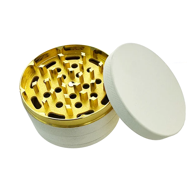 Gold and white herb grinder on a white background