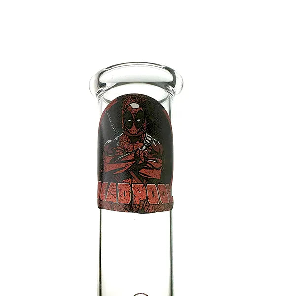 A smoking pipe with a Deadpool character design, featuring a clear glass body and a black base.