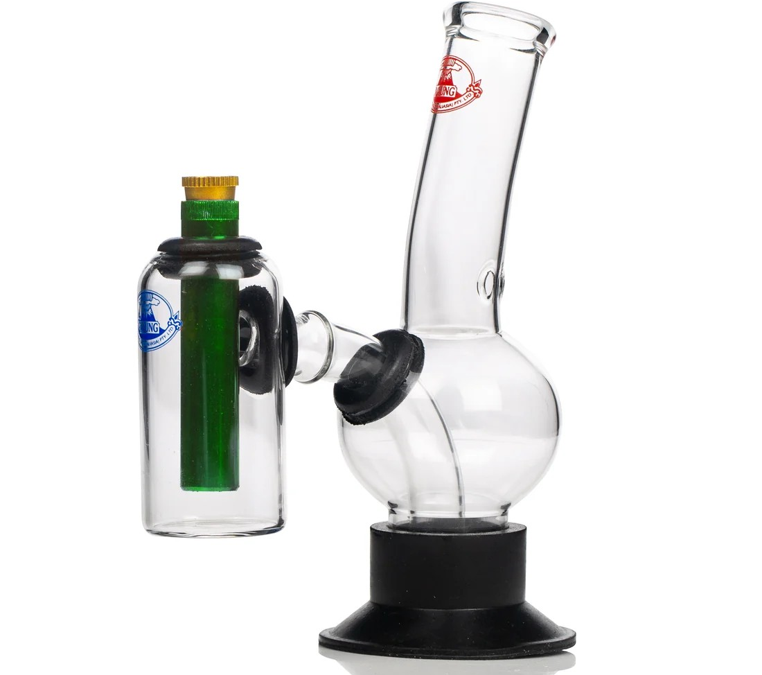 Clear glass water pipe with a black base and a side attachment containing a green inner chamber, photographed on a white background.