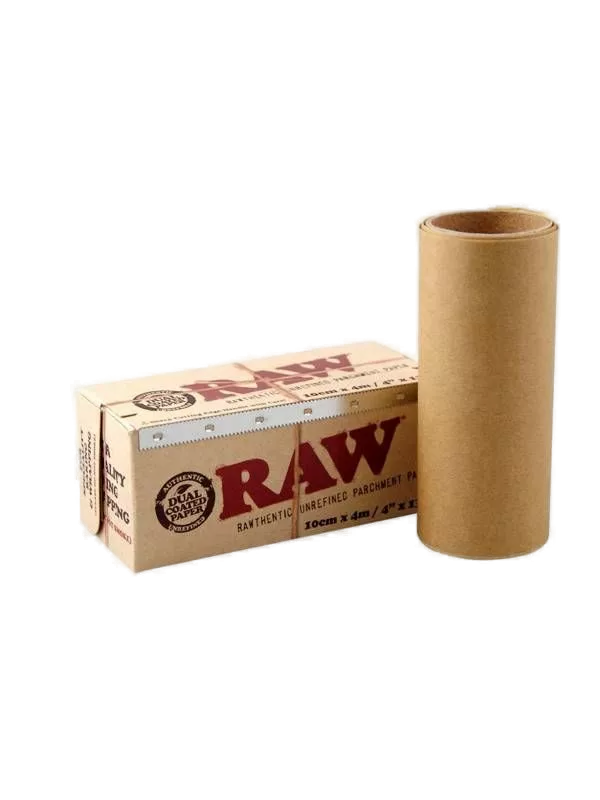 A roll of unrefined parchment paper next to its packaging box, which has the RAW brand logo and the text 'RAW BASICS PAPER' printed on it.